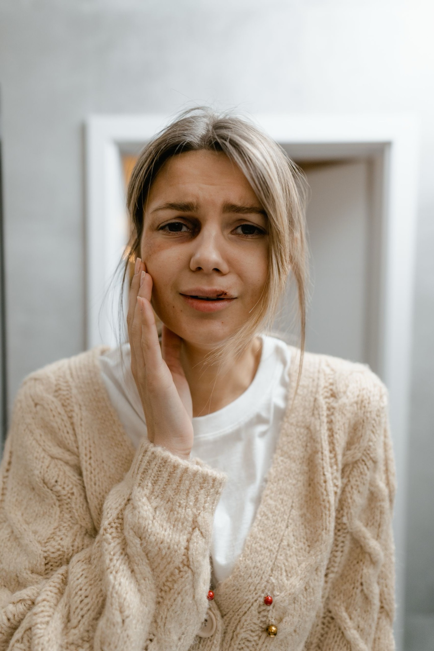 Mujer con dolor dental sosteniéndose la mejilla